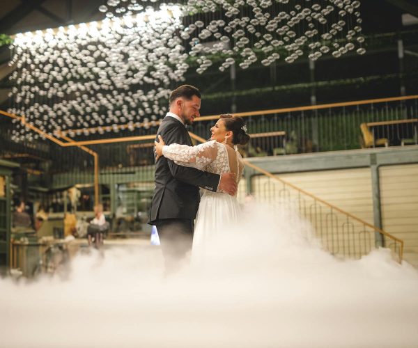 Newlyweds share a romantic dance amidst dreamy decor and soft lighting.